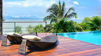 Lounge chairs next to a pool on the beachside