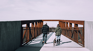 man and woman walking a dog